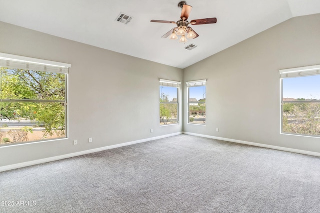 spare room with carpet, visible vents, vaulted ceiling, and a ceiling fan