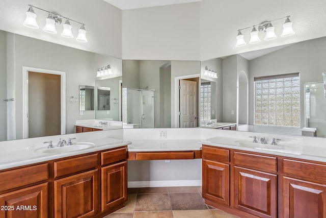 full bathroom with a bath, a sink, a stall shower, and two vanities