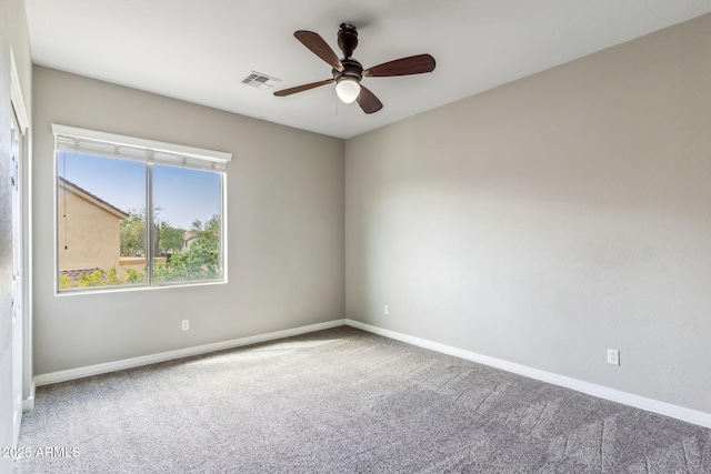 carpeted empty room with baseboards, visible vents, and ceiling fan