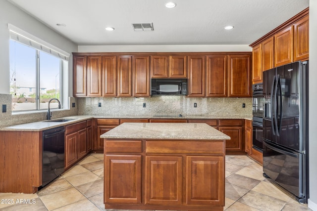 kitchen with backsplash, a sink, a center island, visible vents, and black appliances