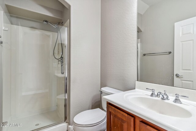 full bathroom with toilet, vanity, a textured wall, and a shower stall