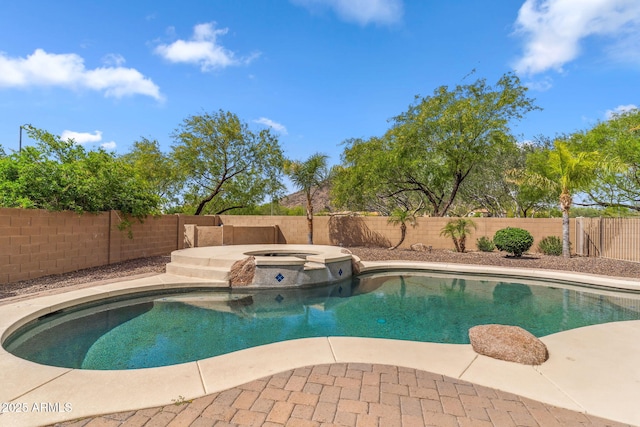 view of pool featuring a fenced backyard and a pool with connected hot tub