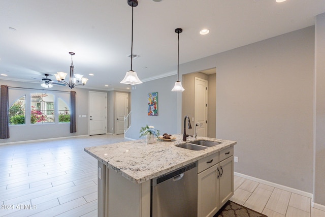 kitchen featuring light stone counters, sink, stainless steel dishwasher, and a center island with sink