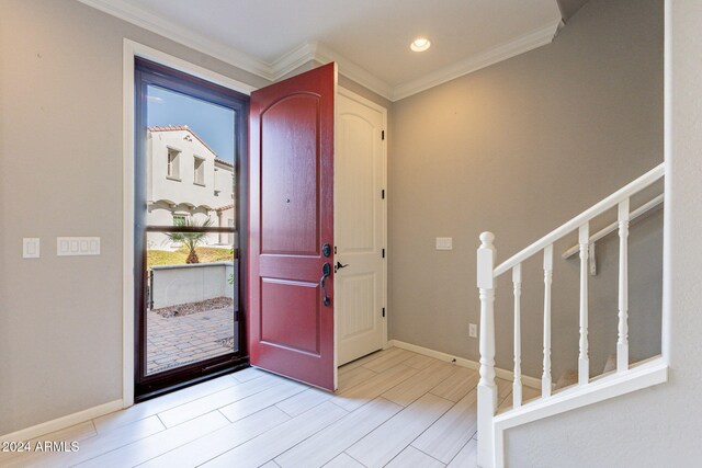 entrance foyer with light hardwood / wood-style flooring and crown molding