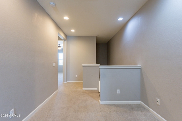 hallway featuring light colored carpet