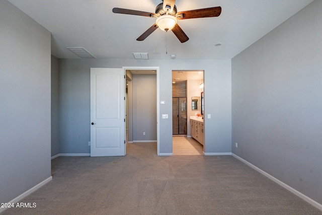 unfurnished bedroom featuring light carpet, ensuite bath, and ceiling fan