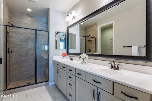 bathroom with vanity and a shower with door