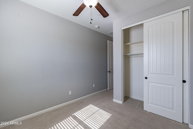 unfurnished bedroom featuring a closet, light colored carpet, and ceiling fan