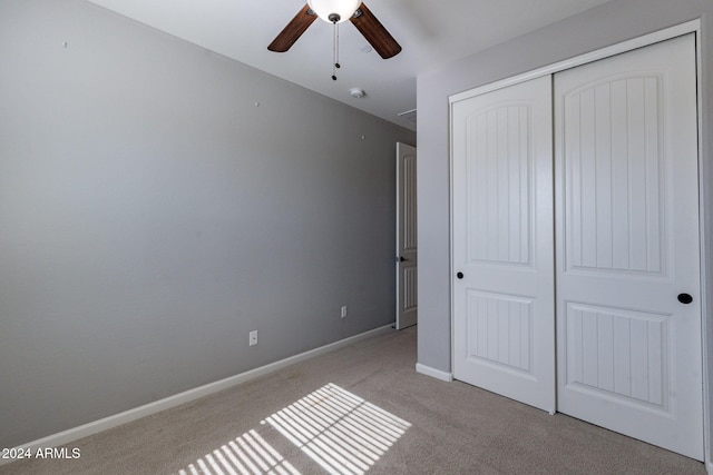 unfurnished bedroom featuring a closet, ceiling fan, and light carpet