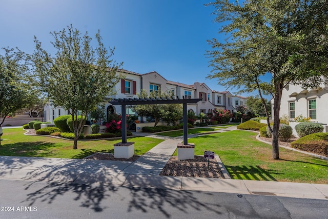 view of property's community featuring a yard and a pergola