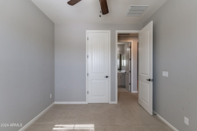 unfurnished bedroom featuring light carpet and ceiling fan