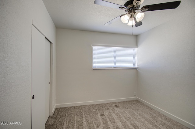unfurnished bedroom featuring baseboards, a ceiling fan, carpet flooring, and a closet