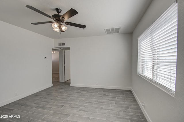 unfurnished room with ceiling fan, baseboards, and visible vents
