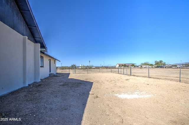 view of yard with fence and a rural view