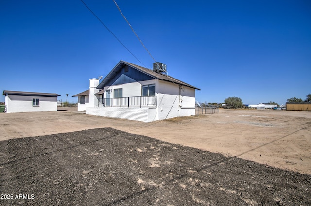 view of side of home with brick siding and central AC