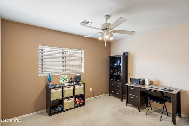 office space featuring visible vents, light colored carpet, baseboards, and ceiling fan