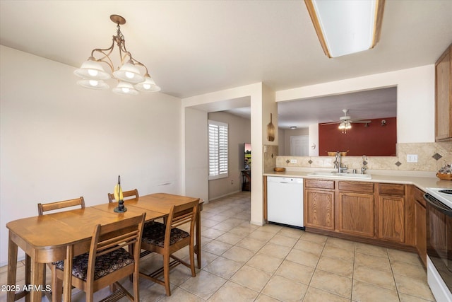 kitchen featuring tasteful backsplash, range with electric cooktop, dishwasher, brown cabinetry, and a sink