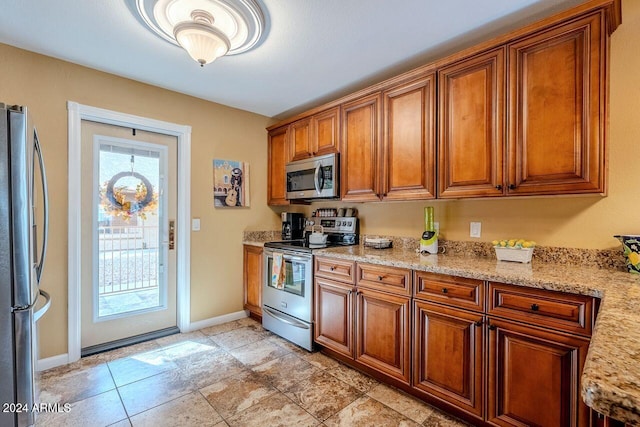 kitchen with stainless steel appliances and light stone counters