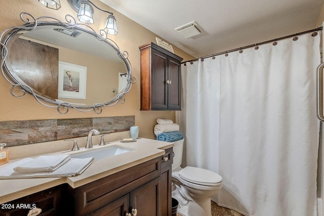 bathroom featuring vanity, a textured ceiling, and toilet