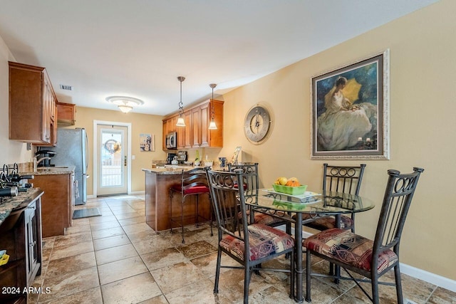 kitchen featuring light stone countertops, kitchen peninsula, and hanging light fixtures