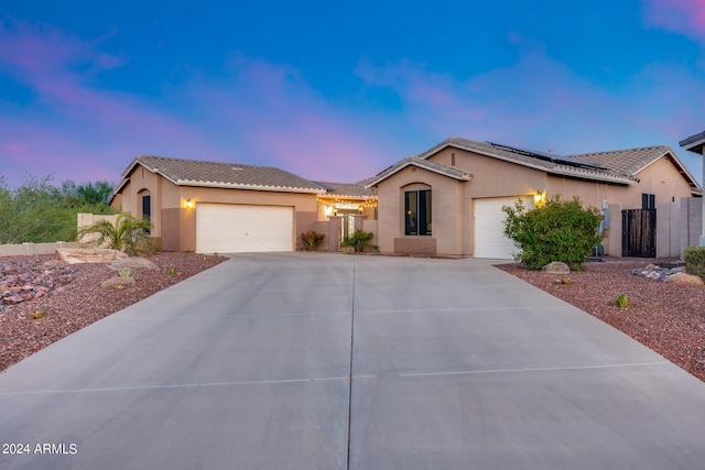 view of front of property featuring a garage and solar panels