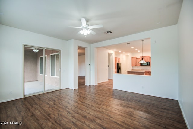 unfurnished living room featuring dark wood-type flooring and ceiling fan