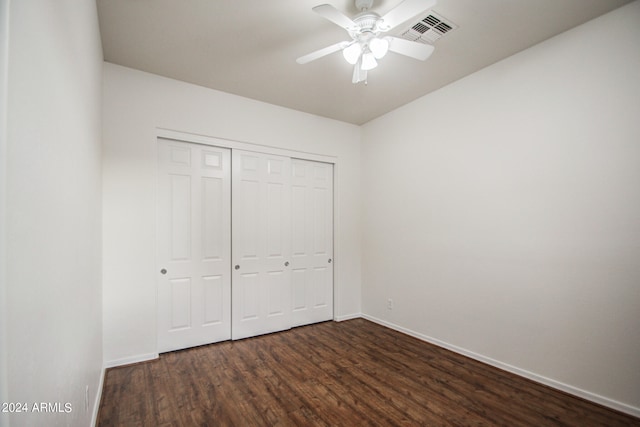 unfurnished bedroom with dark hardwood / wood-style flooring, a closet, and ceiling fan