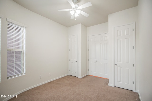 unfurnished bedroom featuring light carpet and ceiling fan