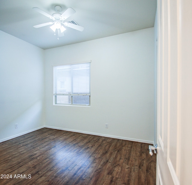 spare room with dark wood-type flooring and ceiling fan