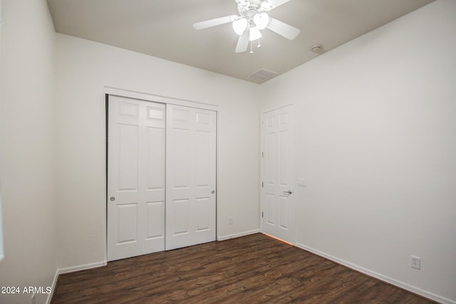 unfurnished bedroom featuring dark wood-type flooring, ceiling fan, and a closet