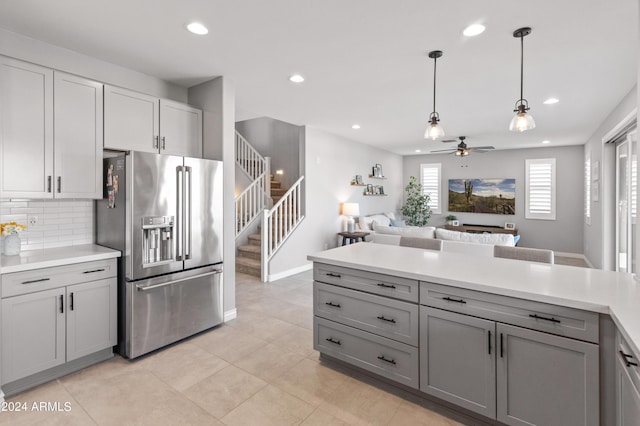 kitchen featuring high quality fridge, ceiling fan, decorative light fixtures, backsplash, and gray cabinets