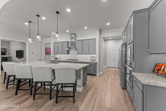 3326 Josey Wales Way, Wickenburg, AZ 85390 - kitchen with wall chimney range hood, gray cabinetry, a sink, stainless steel appliances, and light stone countertops