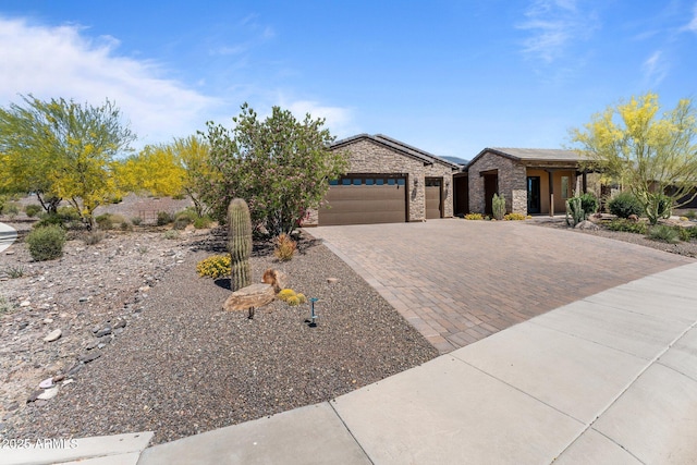 3326 Josey Wales Way, Wickenburg, AZ 85390 - view of front of property with a garage, decorative driveway, solar panels, and stone siding