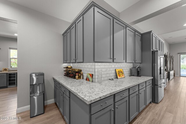 3326 Josey Wales Way, Wickenburg, AZ 85390 - kitchen with freestanding refrigerator, wine cooler, gray cabinets, decorative backsplash, and light wood-style floors