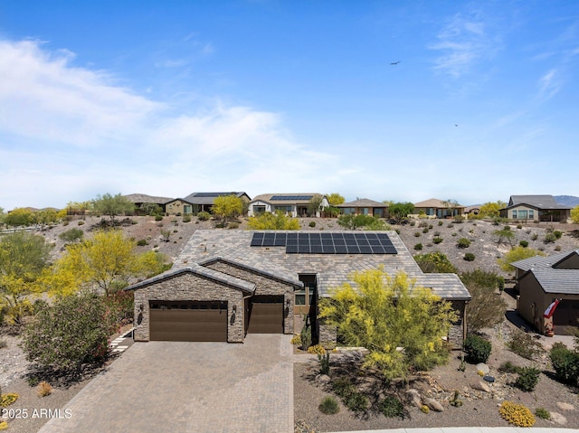 3326 Josey Wales Way, Wickenburg, AZ 85390 - view of front of house featuring an attached garage, stone siding, decorative driveway, and solar panels