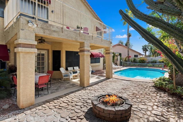 view of swimming pool featuring a patio, ceiling fan, and an outdoor fire pit