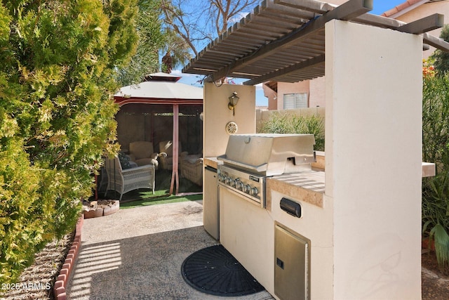 view of patio featuring an outdoor kitchen and a grill