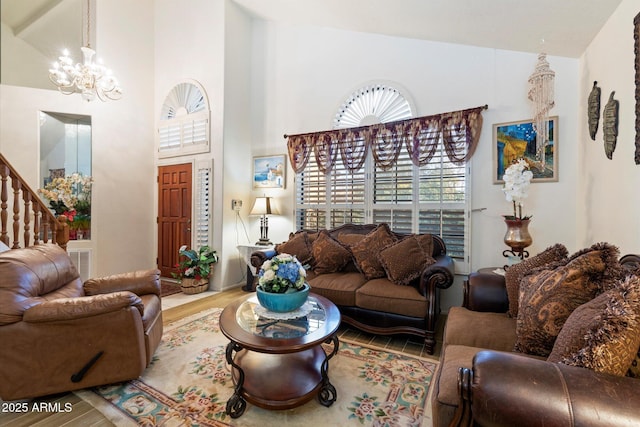 living room featuring hardwood / wood-style floors, high vaulted ceiling, and a chandelier