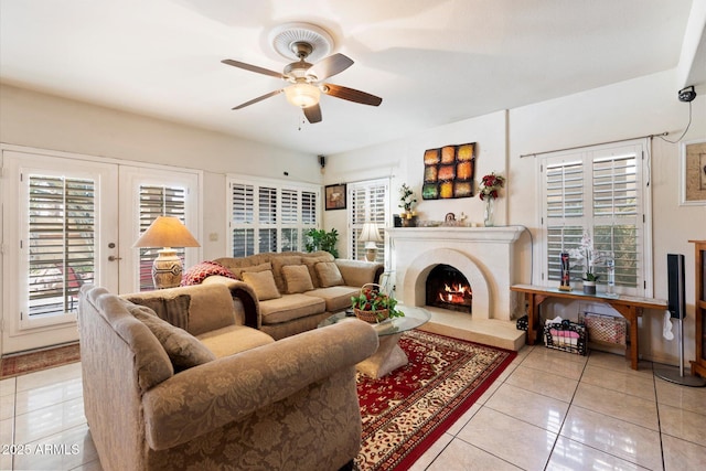 tiled living room with ceiling fan and french doors