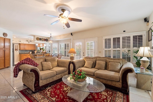 tiled living room featuring ceiling fan and french doors