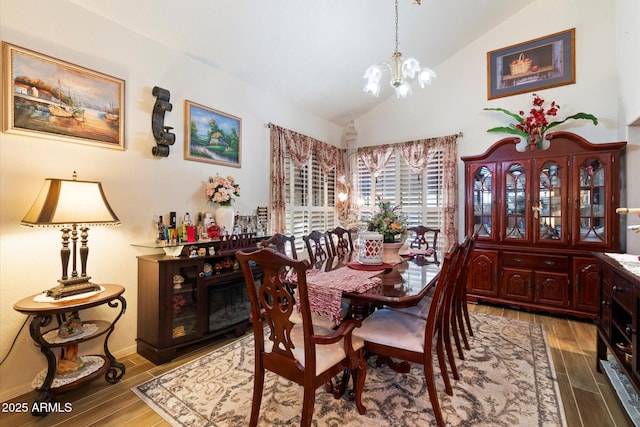 dining room with an inviting chandelier and high vaulted ceiling