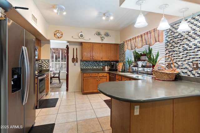 kitchen with decorative light fixtures, sink, light tile patterned floors, kitchen peninsula, and stainless steel appliances