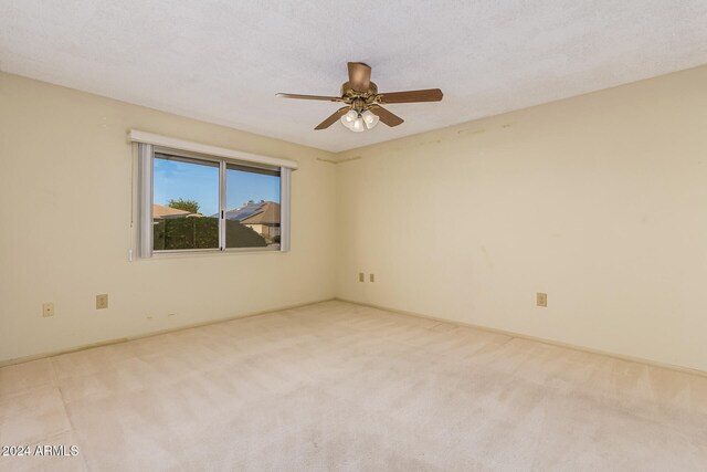 unfurnished room with a textured ceiling, light colored carpet, and ceiling fan