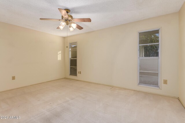 spare room with light carpet, a textured ceiling, and ceiling fan