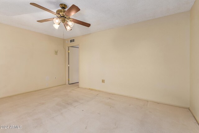 carpeted spare room with ceiling fan and a textured ceiling