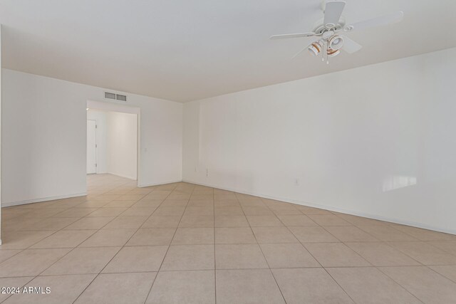 tiled spare room with ceiling fan