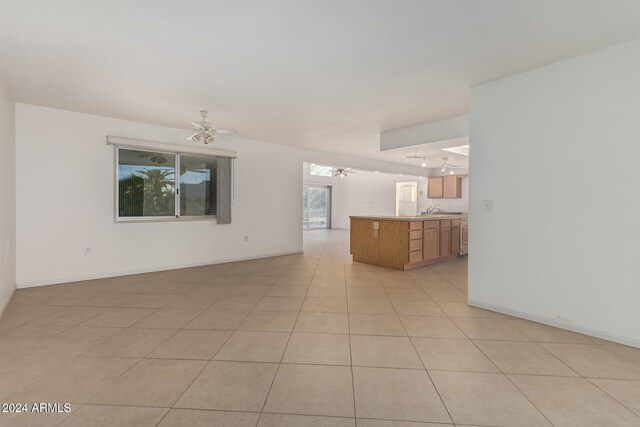 unfurnished living room with ceiling fan and light tile patterned flooring