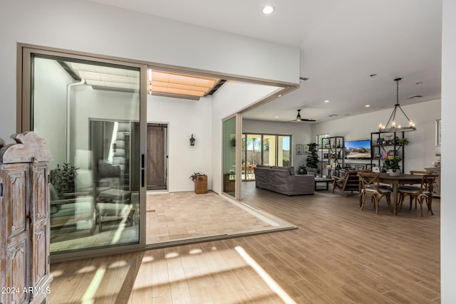 interior space with wood-type flooring and ceiling fan with notable chandelier