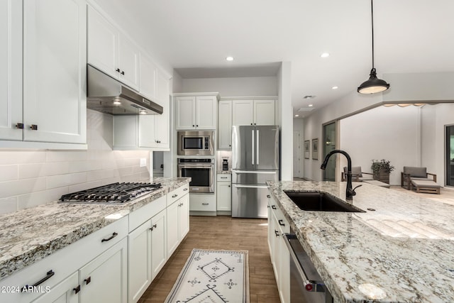 kitchen featuring white cabinetry, sink, stainless steel appliances, dark hardwood / wood-style floors, and decorative light fixtures