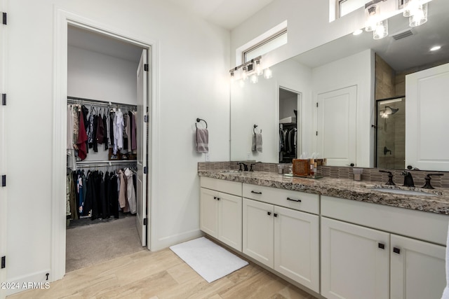 bathroom with a shower with door and vanity